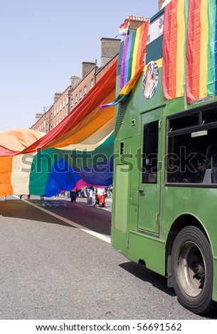 Green bus covered with rainbow LGBT flags