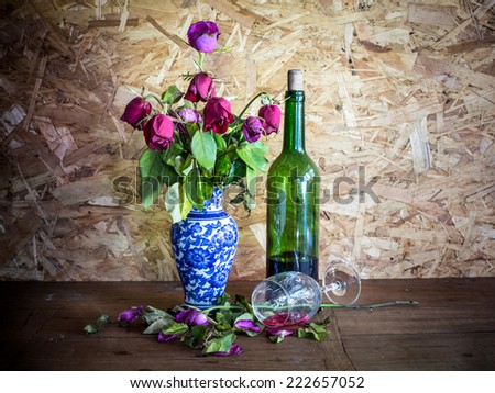 Still life, withered roses and unpalatable wine