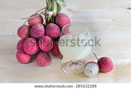 Fresh lychee juice in glass on wooden background