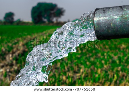 crystal clear sweet and healthy water being flush out by a heavy diesel engine tube well  in the wheat fields where the river water can\'t reach