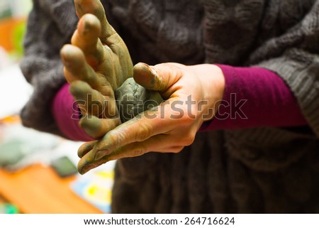 Hands stained with clay and paint. Hands painter and sculptor. Children's creativity and a hobby for adults. Modeling. Hands and fingers stained with paint.