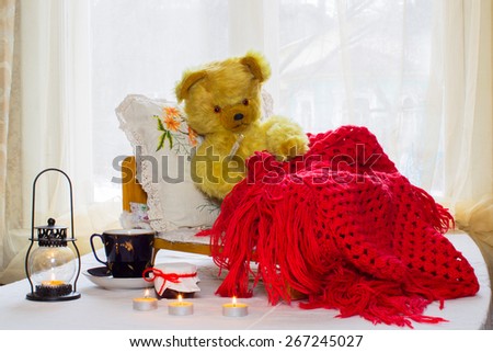 Bear - a toy is in the crib, and measures the temperature of the thermometer near the Bears candles, jar of jam, a cup of tea. Bear sheltered warm red knitted shawl.