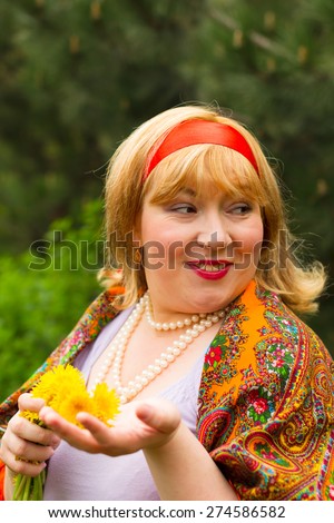 Cheeked Russian cheerful young woman in a wreath of fresh dandelion, flirt, flirty look