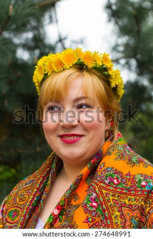 Cheeked Russian cheerful young woman in a wreath of fresh dandelion, flirt, flirty look
