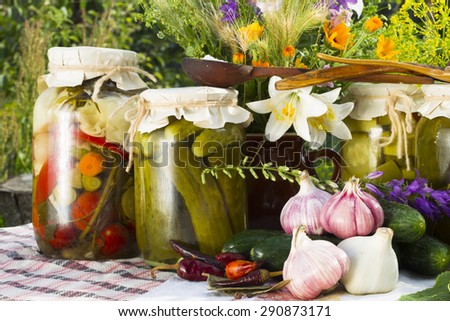 Banks with pickled vegetables - cucumbers, tomatoes, zucchini, and all the ingredients for their salting and preservation-salt, sugar, allspice, pepper, chili hot pepper, bay leaf, spices, dill,garlic