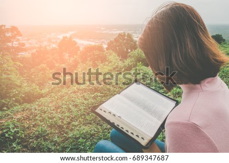 Woman Reading Bible on Mountain in the Morning with copy space