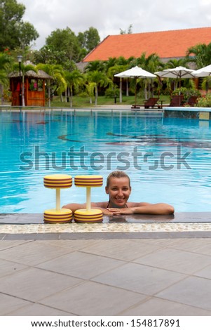 Water aerobics. woman and aqua equipment, dumbbells