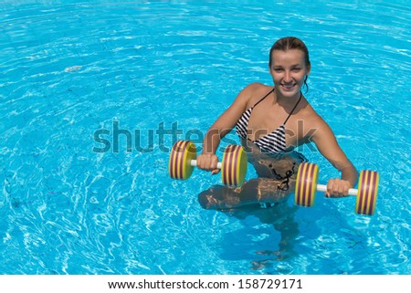 Woman is engaged aqua aerobics in water