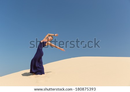 beautiful adult sensuality woman in dress on blue sky and sand background