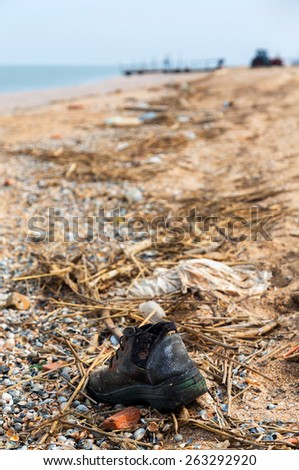 Pollution: shoes,  garbages, plastic, and wastes on the beach after winter storms. Azov sea. dolganka