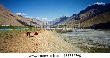 Spiti Valley, Himachal Pradesh, India - circa August 2000: Tibetan monks resting by the Spiti River before Kalachakra circa August 2000. Spiti Valley with its monasties is an important Tibetan buddhism centre.