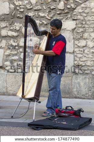 Oxford, England - July 10, 2010: A street musician plays the harp in Broad Street on July 10, 2010.