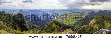 Panoramic photo of Pieniny Mountains, Poland with large vistas of space down below:  peaks, forest, meadows, fields and villages.