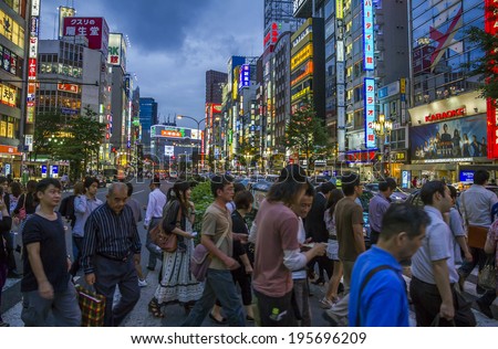 Tokyo, Japan - June 26, 2010: Crowds of people at a busy crossing in Shinjuku district in the evening with neon lights in background on 26 June 2010 in Tokyo, Japan.