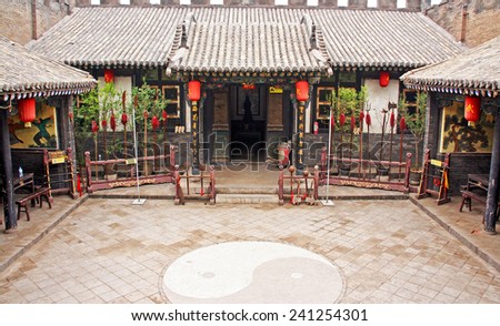 Pingyao, China - July 26, 2009: Ornamental courtyard of a historical house in Pingyao with large collection of chinese traditional wu-shu weapons on July 26, 2009.