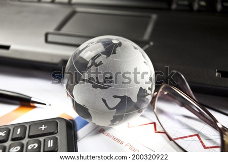 Globe and some business accessories on business documents with deep shadows.