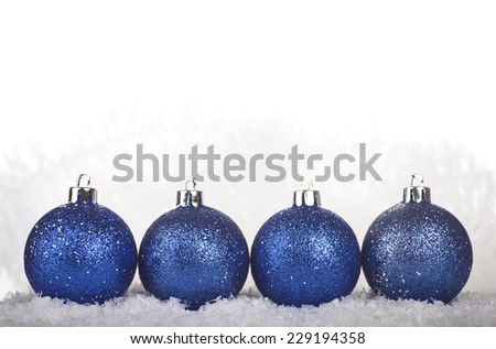 Blue Christmas balls in the snow on a white background.