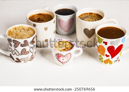 Lots of coffee in different cups with hearts.