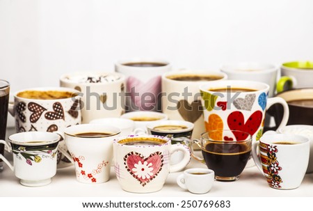 Lots of coffee in different cups with hearts and flowers. Copy space.