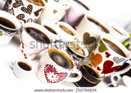 Lots of coffee in different cups with hearts and flowers.