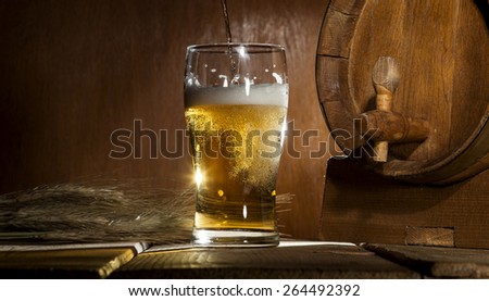 Beer barrel with beer mug on a wooden dark background.