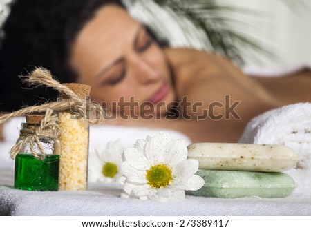 Beautiful Woman Getting Spa Massage in Spa Salon. Focus on the flower.