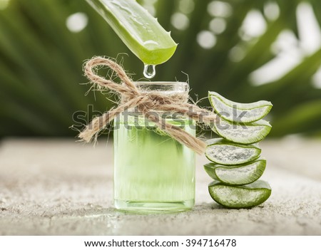 Aloe vera essential oil on tropical leaves background