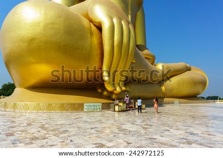 Believers with large buddha\'s finger, with shade from sunlight, travel location on public area