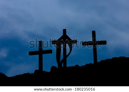 three wooden crosses and clouds