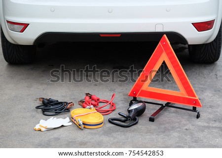 Car emergency kit, Battery Jumper cable, Tow cable, flashlight, gloves, hazard triangle warning sign.