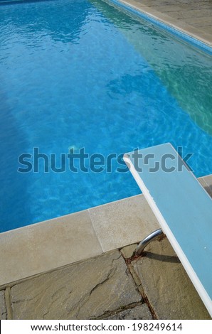 Outdoor swimming pool with diving board.