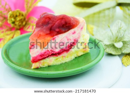 Strawberry cheese cake and cherry sauce on green dish