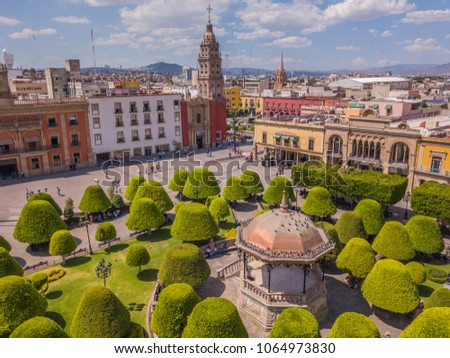 Main square in the center of Leon Guanajuato with a copper kiosk in the center, in the background the city and the Parroquia del Sagrario