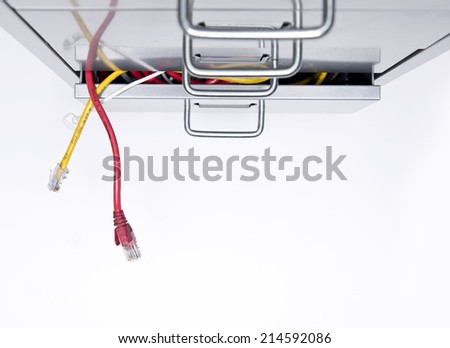 Computer cables sticking out of the draw of a filing cabinet