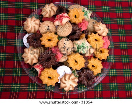 Top view of plate of assorted cookies on a red and green plaid placemat.