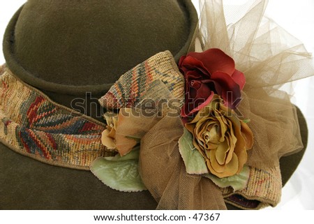 Brown felt hat with brown ribbon and floral decoration.