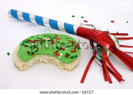Sugar cookie with green icing and red, white, green sprinkles next to a party favor.