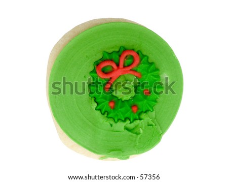 Sugar cookie with green icing and red Christmas wreath decoration on top.