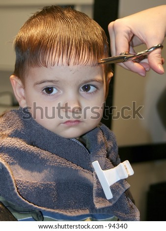 Small boy getting his first hair cut.