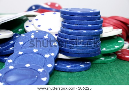 Poker chips and cards on a green felt top table.