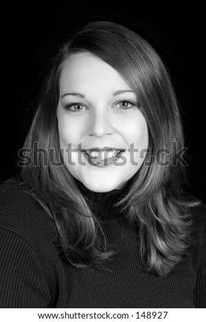 Black on black portrait of a beautiful young woman with brown hair and bright blue eyes.