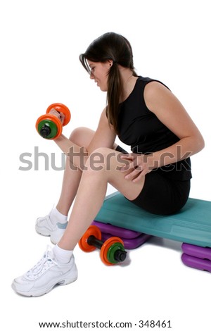 Teen Girl Holding Colorful Weights while sitting on aerobic step Over