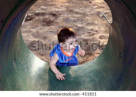 Boy Laughing And Playing With The Slide at the park.