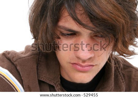 stock photo Close up of teen boy crying Tears in eyes and on cheeks