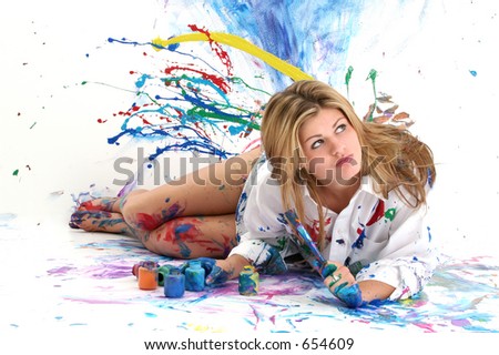 Beautiful young woman laying in paint covered studio.  Paint splattered on walls, floor, model.  Shot in studio over \