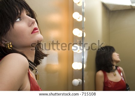 Profile and reflections of beautiful young woman in Red Vinyl dress.