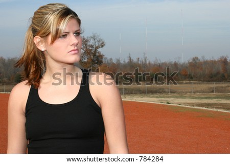 Young woman in black tank top outside at jogging track.
