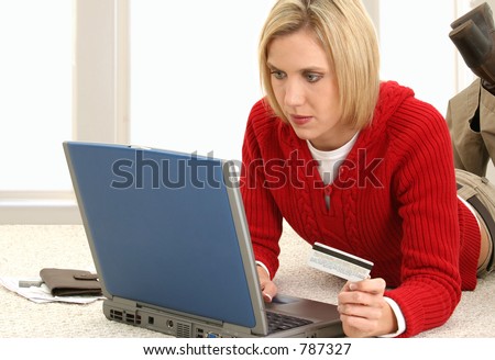 Casual young woman at home making online credit card payments.