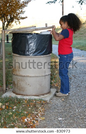 Seven year old child throwing away trash at the park.