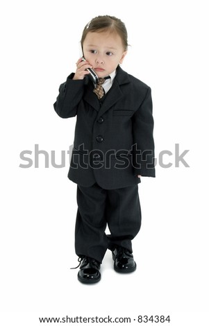 Two year old Japanese American girl in suit and tie with cellphone.